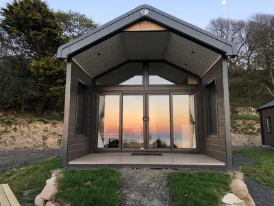 a large window in the front of a building at POD1 Family Glamping with seaview & Wi-Fi in Llwyngwril