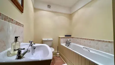 a bathroom with a sink and a tub and a toilet at Below the castle at Snowdonia in Harlech