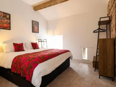 a bedroom with a large bed and a window at Threshers Barn in Oswestry