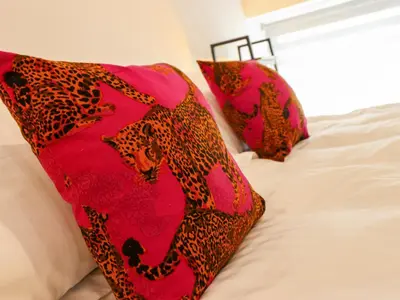 a bed with two red pillows on it at Threshers Barn in Oswestry