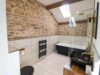 a bathroom with a sink and a bath tub at Threshers Barn in Oswestry