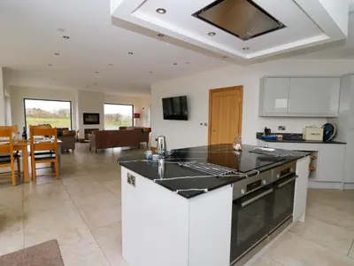a kitchen with a sink and a stove top oven at Rhandir Hen in Aberystwyth