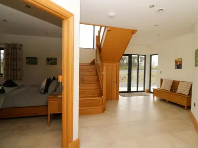 a bedroom with a bed and a staircase in a house at Rhandir Hen in Aberystwyth