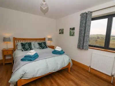 a bedroom with a bed with two towels on it at Rhandir Hen in Aberystwyth