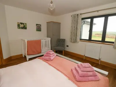 a bedroom with a bed with pink towels on it at Rhandir Hen in Aberystwyth
