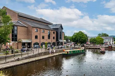 a boat in a river in front of a building at 2 Bed in Llangorse oc-t30290 in Llangorse