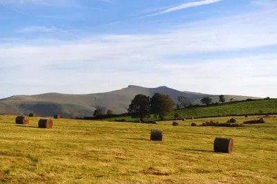 a field of hay bales in a field with mountains at 2 Bed in Llangorse oc-t30290 in Llangorse