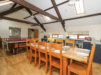 a kitchen and dining room with a wooden table and chairs at Llwyngwinau Isaf Barn in Tregaron
