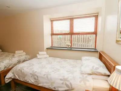 a small bedroom with two beds and a window at Llwyngwinau Isaf Barn in Tregaron