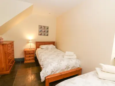 a small bedroom with a bed and a dresser at Llwyngwinau Isaf Barn in Tregaron