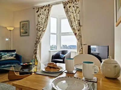 a table with a plate of food on top of it at Green Hill ground floor Family Apartment in Barmouth