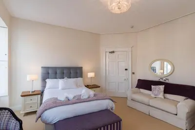 a bedroom with a large bed and a couch at No 46 Marine Terrace in Aberystwyth