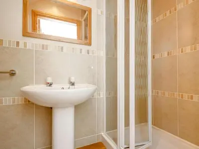 a bathroom with a sink and a shower at Tan-y-Graig at Snowdonia in Harlech