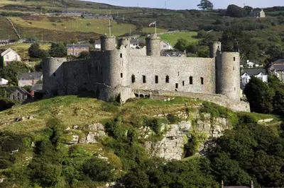 a castle on top of a hill with trees at Tan-y-Graig at Snowdonia in Harlech