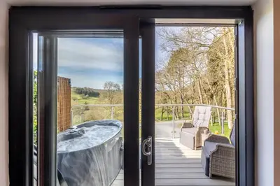 a door leading to a deck with a tub at 1 Bed in Berriew oc-a31113 in Berriew