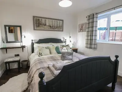 a bedroom with a large bed and a window at Blockley Lodge in Church Stretton