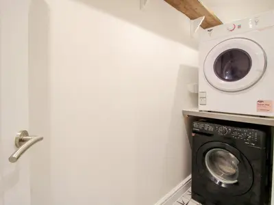 a laundry room with a washer and a washing machine at Blockley Lodge in Church Stretton