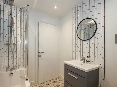 a bathroom with a sink and a mirror and a shower at Blockley Lodge in Church Stretton