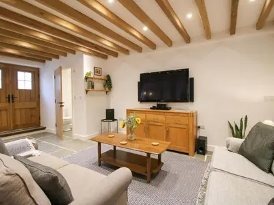 a living room with a couch and a tv at The Hideaway in Bishops Castle