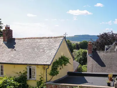 a yellow house with a gray roof at The Hideaway in Bishops Castle