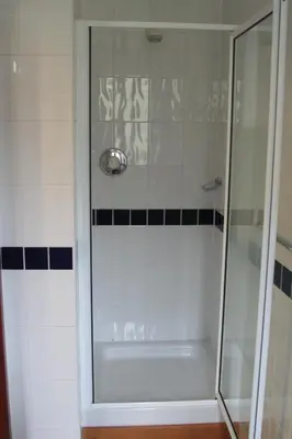 a shower with a glass door in a bathroom at Elan Valley Lodge in Llanwrthwl
