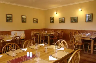 a dining room with wooden tables and chairs at Elan Valley Lodge in Llanwrthwl