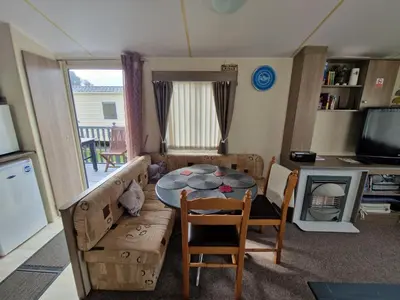 a small living room with a table and chairs at Ocean Breeze Hideaway 2 Bed Pet Friendly Static Caravan In Clarach Bay in Aberystwyth