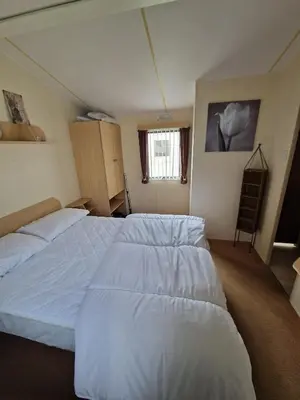 a bedroom with two beds and a window at Ocean Breeze Hideaway 2 Bed Pet Friendly Static Caravan In Clarach Bay in Aberystwyth