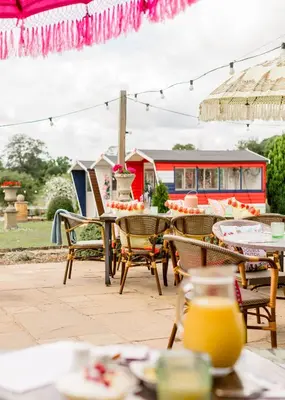 an outdoor patio with tables and chairs and a bus at Sweeney Hall Hotel in Oswestry
