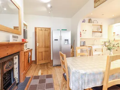 a kitchen with a table and a refrigerator at Mor Iwerddon in Barmouth