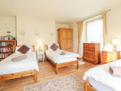 a bedroom with two beds and a book shelf at Mor Iwerddon in Barmouth