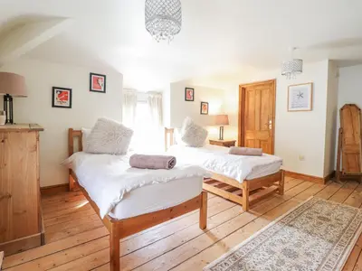 two beds in a room with wooden floors at Mor Iwerddon in Barmouth