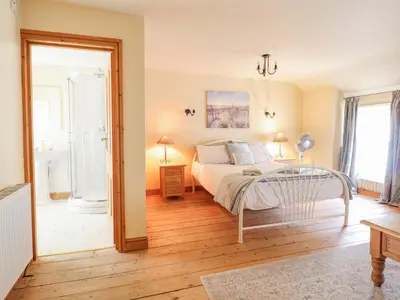 a bedroom with a bed and a bathroom at Mor Iwerddon in Barmouth