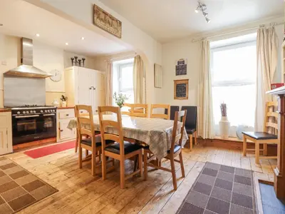 a kitchen with a dining room table and chairs at Mor Iwerddon in Barmouth