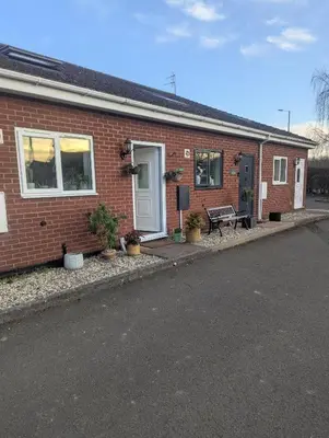 a brick house with a bench in front of it at Number 46 in Bicton