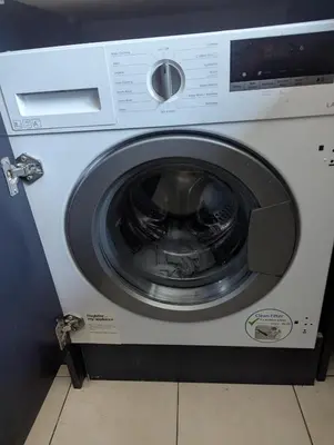a white washing machine sitting in a room at Number 46 in Bicton