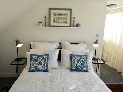 a bedroom with a bed with blue and white pillows at The Loft - Shrewsbury in Shrewsbury