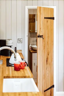 a kitchen with a wooden counter top with a sink at Shepherd's Hut at Lythwood, Near Shrewsbury in Baystonhill