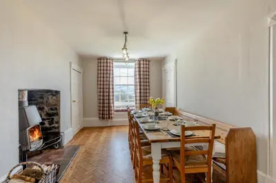 a dining room with a table and a fireplace at 5 Bed in Hundred House oc-l31090 in Hundred House