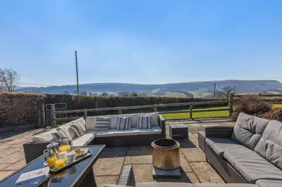 a patio with couches and a table with drinks on it at 5 Bed in Hundred House oc-l31090 in Hundred House