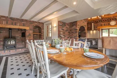 a kitchen and dining room with a wooden table and chairs at Stud Farm House in Bleddfa