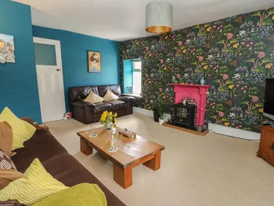 a living room with a couch and a fireplace at Cantref House Top Floor in Brecon