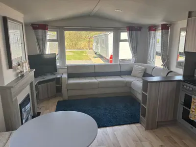 a living room with a couch and a tv at Sea Breeze Retreat 2 Bedroom Pet Friendly Caravan in Clarach Bay in Aberystwyth