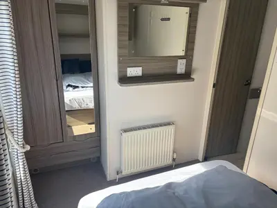a room with a closet with a mirror and a bed at Sea Breeze Retreat 2 Bedroom Pet Friendly Caravan in Clarach Bay in Aberystwyth