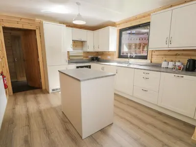 a kitchen with white cabinets and a counter top at Sunset Lodge 5 in Llanbedr