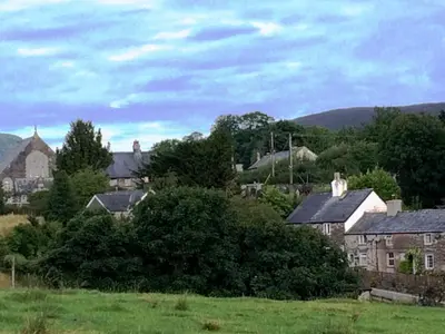 a group of houses in a green field at Cosy cottage in Snowdonia hamlet in Frongoch