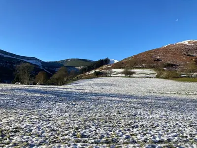 a large gravel road with a mountain in the background at Tyn-Y-Berth Sleeps 27 luxury group accommodation in Tal-y-llyn