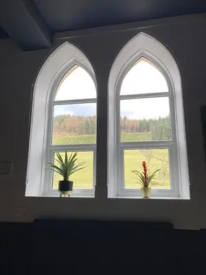 two windows in a room with two potted plants at Tyn-Y-Berth Sleeps 27 luxury group accommodation in Tal-y-llyn