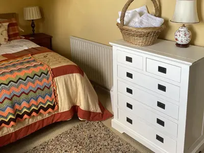 a bedroom with a bed and a basket on a dresser at 10 Upper Linney in Ludlow