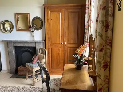 a living room with a fireplace and a chair at 10 Upper Linney in Ludlow
